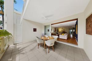 a dining room and living room with a table and chairs at Tidal Haven in Noosaville