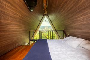 a bed in a room with a large window at Villa de los Vientos in Cuetzalán del Progreso +55 photos