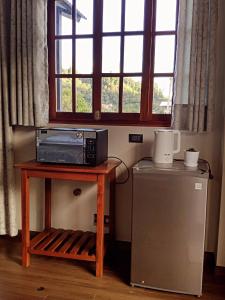 a microwave on a table next to a small refrigerator at Cabaña Monte Santo in Oxapampa