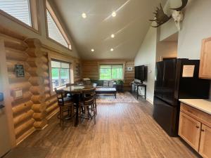 a kitchen and living room with a table and a refrigerator at Clear Creek Cabins in Seward