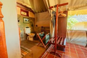 a bathroom with a toilet and a wooden ladder at Buffalo's Rest Greenpark-Naivasha in Naivasha