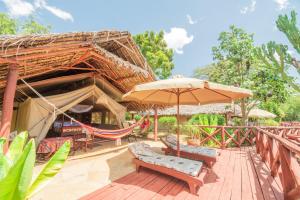 a patio with chairs and an umbrella and a hammock at Buffalo's Rest Greenpark-Naivasha in Naivasha