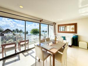 a dining room with a table and chairs and a large window at Grand Boréna Hotel Boutique in Playa del Carmen