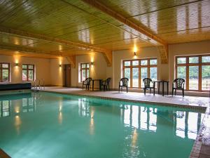 a large swimming pool with chairs and tables at Cleeve- Ukc4922 in Timberscombe +9 photos