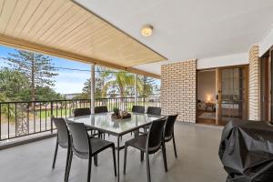 a dining room with a table and chairs on a balcony at Beachfront - Opposite Boat Ramp in Golden Beach