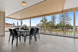 a dining room with a table and chairs on a balcony at Beachfront - Opposite Boat Ramp in Golden Beach