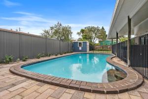 a swimming pool in a backyard with a fence at Beachfront - Opposite Boat Ramp in Golden Beach