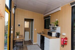 a small kitchen with a sink and a microwave at Saddle House by Tiny Away in Lower Beechmont