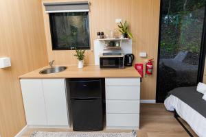 a small kitchen with a sink and a microwave at Saddle House by Tiny Away in Lower Beechmont +27 photos