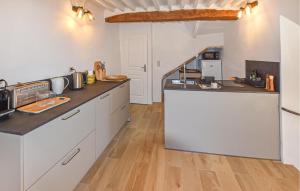a kitchen with white cabinets and a wooden floor at Maison En Pierres in Rustrel