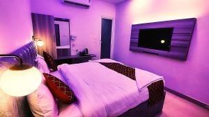 a purple bedroom with a bed and a tv at hotel Gautam Inn in Gorakhpur