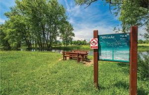 a sign with two benches next to a river at Beautiful Home In Otocac in Otočac