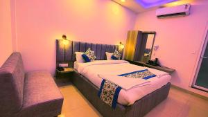 a bedroom with a large bed and a couch at hotel Gautam Inn in Gorakhpur