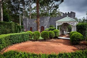 a garden with a gazebo in front of a castle at The Castle on Tamborine in Mount Tamborine