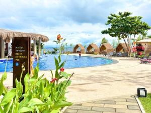 a pool at a resort with people sitting around it at Mactan Newtown Studio Type with Balcony in Punta Engaño