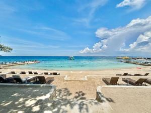a beach with a bunch of chairs and the ocean at Mactan Newtown Studio Type with Balcony in Punta Engaño