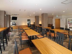 une salle à manger avec des tables et des chaises en bois dans l'établissement Amistad Hotel, à Matsuura