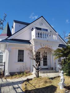 a white house with a tree in front of it at シンデレラ城風 邸宅のゲストハウス民泊 in Tosa