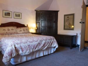 a bedroom with a bed and a dresser and a table at West Wing- Ukc4914 in Timberscombe