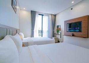 a hotel room with two beds and a television at Intechco Hotel S1-25 sầm Sơn in Sầm Sơn