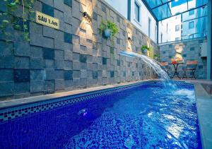 a swimming pool with a fountain in a building at Intechco Hotel S1-25 sầm Sơn in Sầm Sơn