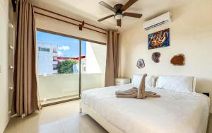 a bedroom with a bed and a large window at Grand Boréna Hotel Boutique in Playa del Carmen