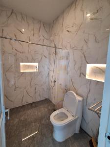 a bathroom with a white toilet and a marble wall at Villa Luck Canggu Bali unit 7 in Canggu +9 photos