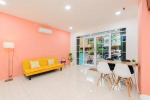 a living room with a yellow couch and a table and chairs at Sans Hotel Cengkareng in Jakarta