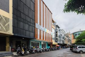 a row of motorcycles parked in front of a building at Sans Hotel Cengkareng in Jakarta
