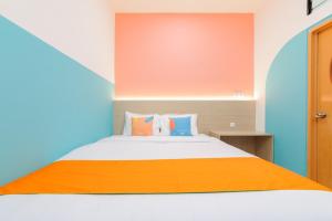 a bedroom with a bed with an orange blanket at Sans Hotel Cengkareng in Jakarta