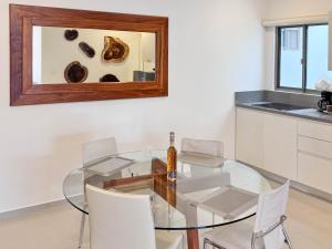 a dining room with a glass table and white chairs at Grand Boréna Hotel Boutique in Playa del Carmen +287 photos