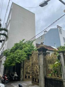 a gold gate in front of a building at Fullhouse Riverside Homestay in Hue