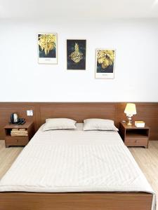 a bedroom with a large white bed with two tables at Fullhouse Riverside Homestay in Hue