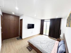 a bedroom with a bed and a flat screen tv at Fullhouse Riverside Homestay in Hue