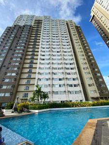 a large building with a swimming pool in front of it at Josephine's place at Avida Aspira Tower 2 CDO in Cagayan de Oro