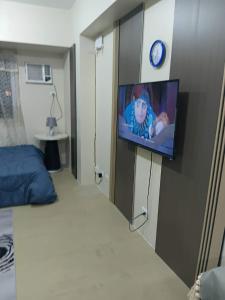 a room with a tv on a wall with a bed at Josephine's place at Avida Aspira Tower 2 CDO in Cagayan de Oro