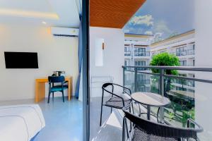 a balcony with a bed and a table and chairs at Nai Yang Beach Resort and Spa in Nai Yang Beach