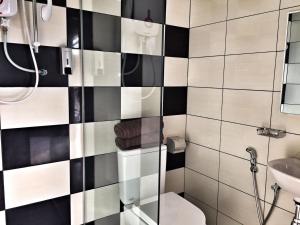 a bathroom with a black and white tiled wall at Destini Akef Villa in Pantai Cenang