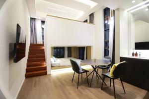 ein Esszimmer mit Tisch und Stühlen und einem Bett in der Unterkunft 루나스카이돔 구 스페이스앤무드 in Busan