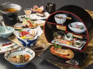 a table topped with bowls and plates of food at Shimoda Central Hotel in Shimoda