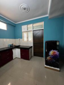 a kitchen with blue walls and a black counter top at Maison Royale House 3bhk apartment in Jaipur