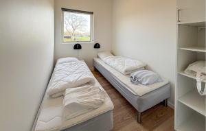 two beds in a small room with a window at 2 Bedroom Nice Apartment In Vejen in Vejen