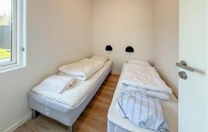 two beds in a room with a window at 2 Bedroom Nice Apartment In Vejen in Vejen +12 photos