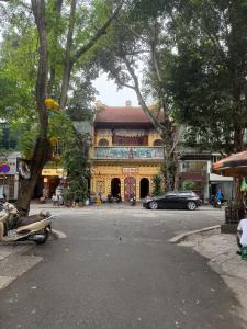 a large yellow building with a car parked in front of it at Hanoi Amie Duplex Homestay in Hanoi