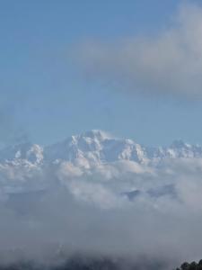 a view of a mountain with clouds in front of it at The Garhwal Huts in Pauri