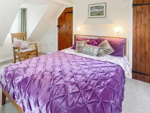 a purple bed in a room with a chair at Denham in Glaisdale +15 photos
