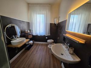 a bathroom with two sinks and a toilet and a mirror at Casa a Pennello Bed & Breakfast - Dove l'arte incontra l'ospitalità in San Benedetto del Tronto +46 photos