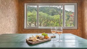 a table with two glasses of wine and a tray of food at Gapyeong Maplein Pension in Pocheon