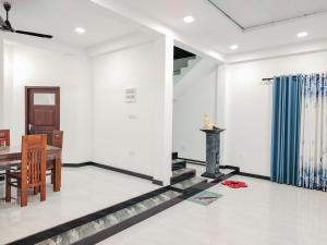 a dining room with white walls and a table at NRS Villa Midigama in Midigama East