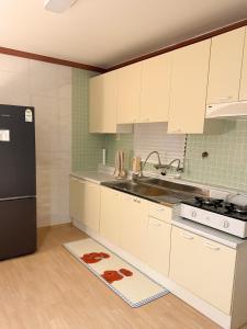 a kitchen with white cabinets and a black refrigerator at juns house in Ulsan +19 photos